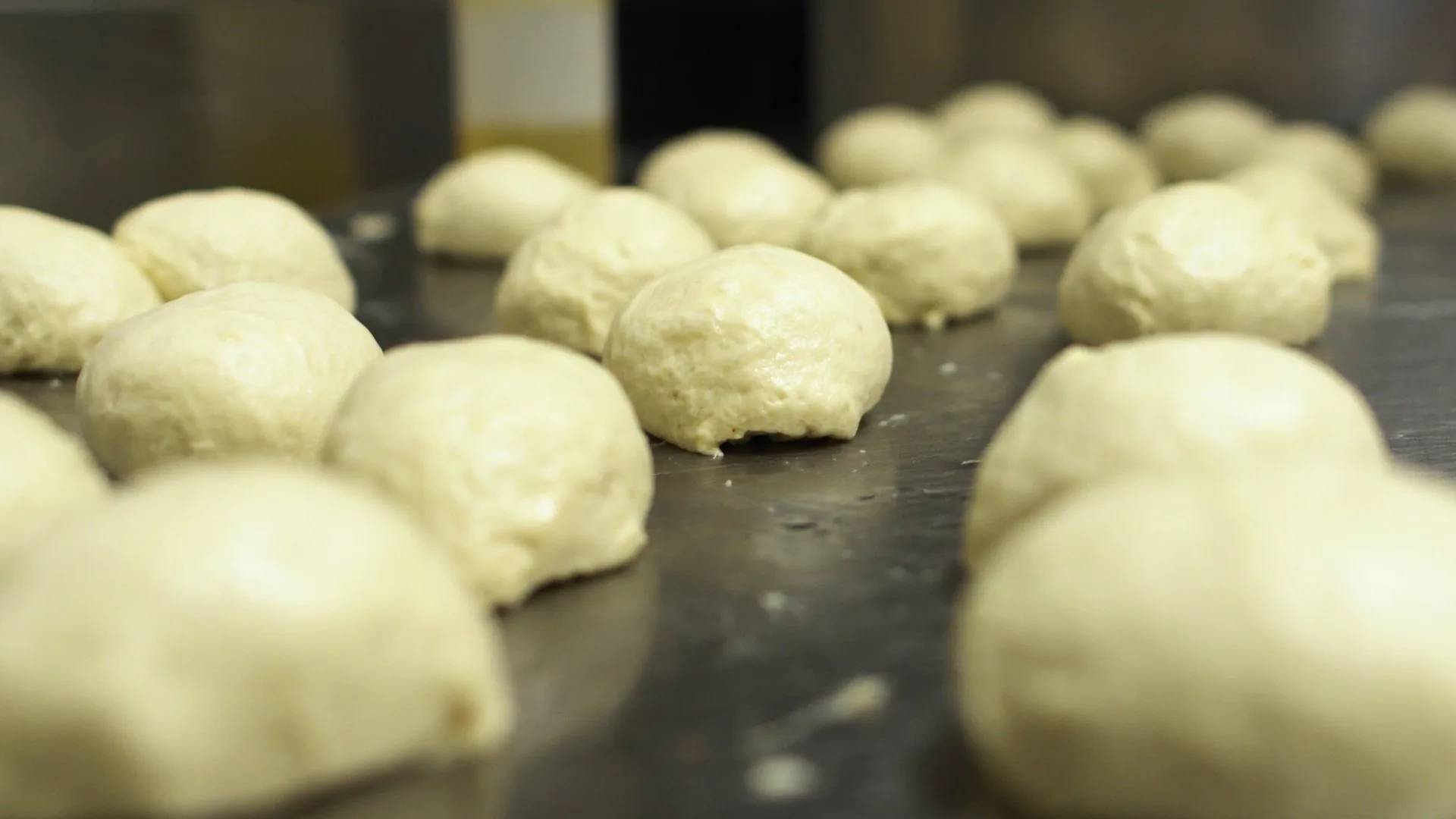 Palline di impasto del pane in lievitazione sul piano di lavoro